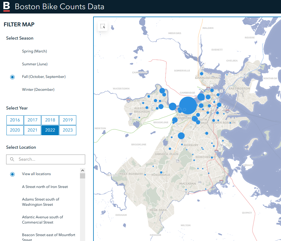 Screenshot of the Boston Bike Counts Data, which shows blue circles over where bike counters are, each circle getting larger where more bikes are counted. A majority of them are centered around the Fenway area, with very few in the southern neighborhoods of Boston.