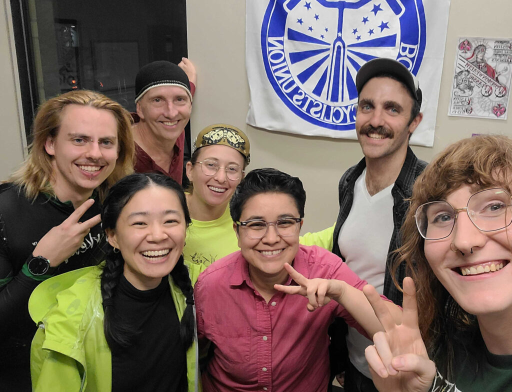 BCU Executive Director Ari Belathar with staff and volunteers all smiling in the BCU office