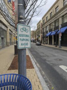 street sign on a city street showing bike parking ahead