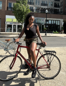 Woman on a city street smiling as she on her red bicycle